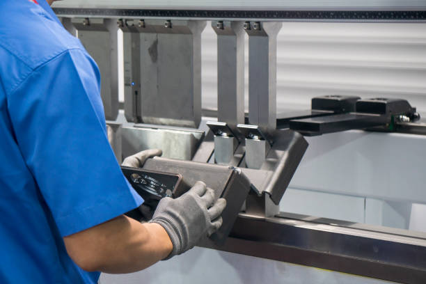 The technician operator working with hydraulic press brake bending machine. The sheet metal working operation by skill operator.